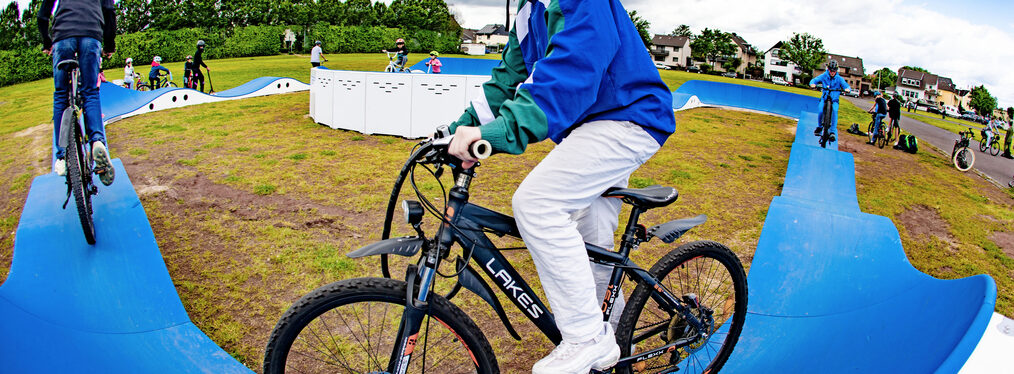 Ein junger Mountainbiker auf einer blauen Fahrbahn