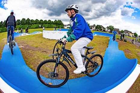 Ein junger Mountainbiker auf einer blauen Fahrbahn