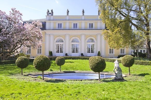 Außenaufnahme der Redoute in Bad Godesberg mit einem Springbrunnen im Vordergrund