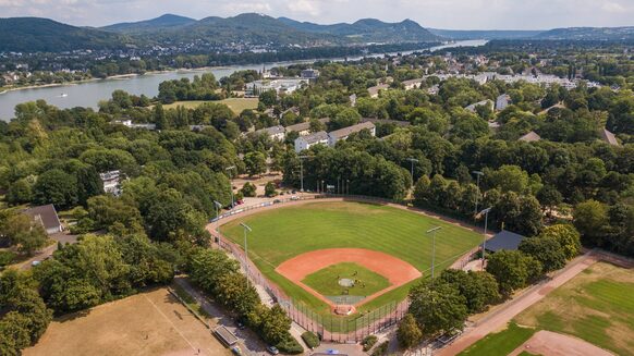 Drohnenaufnahme des Baseballstadions Bonn. Im Hintergrund Rhein und Siebengebirge.