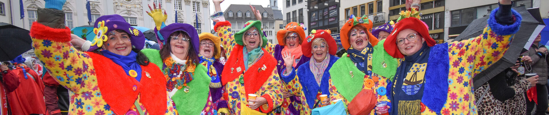 Eine Gruppe Frauen bunt als Blumenkinder verkleidet