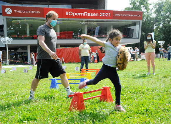 En Mädchen und ein erwachsener Mann beim Aktionstag des Stadtsportbundes auf dem Opernrasen