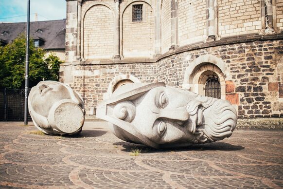 Die Steinköpfe von Cassius (links) und Florentius vor dem Bonner Münster