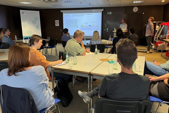 Gruppe von Personen vor einer Powerpoint-Präsentation