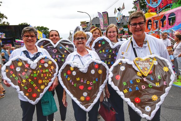 Mehrere Frauen mit riesigen Lebkuchenherzen um den Hals