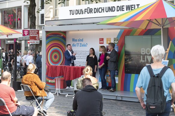 An einem Infostand sind mehrere Personen miteinander im Gespräch