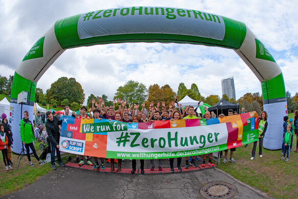 Eine große Menschenmenge steht hinter einem Banner und wartet auf den Startschuss zum ZeroHungerRun