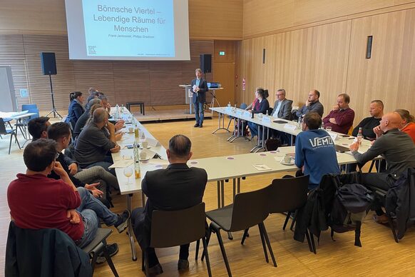 Das Bild zeigt rund 20 Menschen in einem Seminarraum der Stadt, die über Wirtschaftsverkehr sprechen.