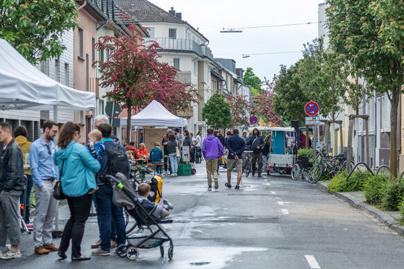 Das Bild zeigt Menschen auf einer Straße im Combahnviertel, die zum Tag der Bönnschen Viertel gekommen sind.