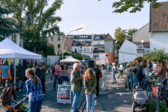 Das Bild zeigt viele Kinder und Erwachsene, die auf der Magdalenenstraße ein Fest feiern.