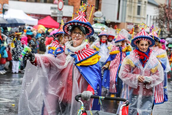 Bunt kostümierte Frauen mit durchsichtigen Regencapes