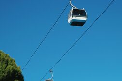 Zwei Kabinen einer Seilbahn vor blauem Himmel