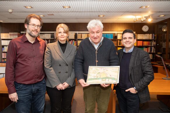 Dr. Norbert Schloßmacher und Stephan Rothkegel vom Bonner Heimat- und Geschichtsverein (rechts) übergeben die Karte an Dr. Yvonne Leiverkus (Leiterin) und Markus Ernzerhoff vom Stadtarchiv Bonn.