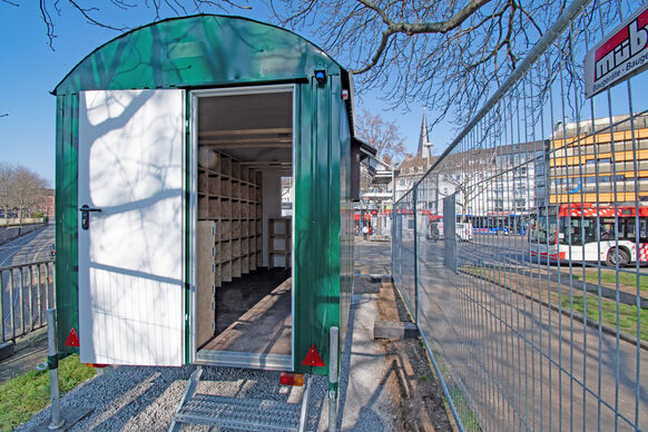 Das Bild zeigt einen eingezäunten Bauwagen, im Hintergrund der Zentrale Omnibus-Bahnhof.