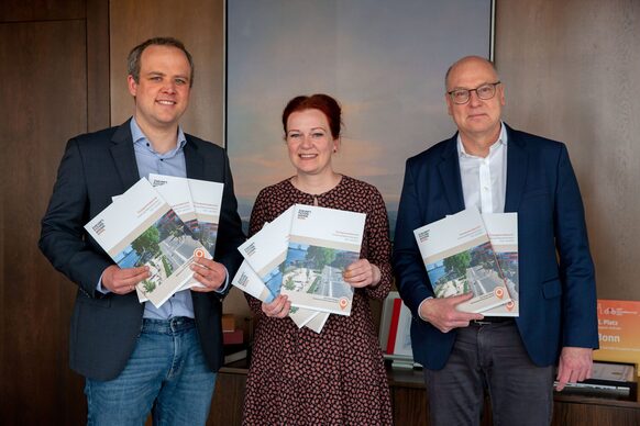 Vertreter*innen der Stadtverwaltung mit dem Transparenzbericht in ihren Händen.