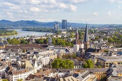 Blick vom Stadthausdach auf die Bonner Innenstadt. Im Hintergrund sind Posttower, UN-Tower und Siebengebirge.