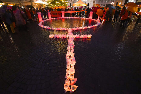 Das Bild zeigt das Frauensymbol, geformt aus Lichtern, auf dem Markt. Anlass ist der Internationale Tag gegen Gewalt an Frauen.