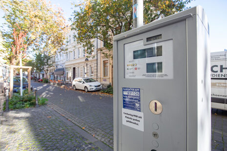 Das Bild zeigt einen eingeschalteten Parkscheinautomaten in der Breite Straße.