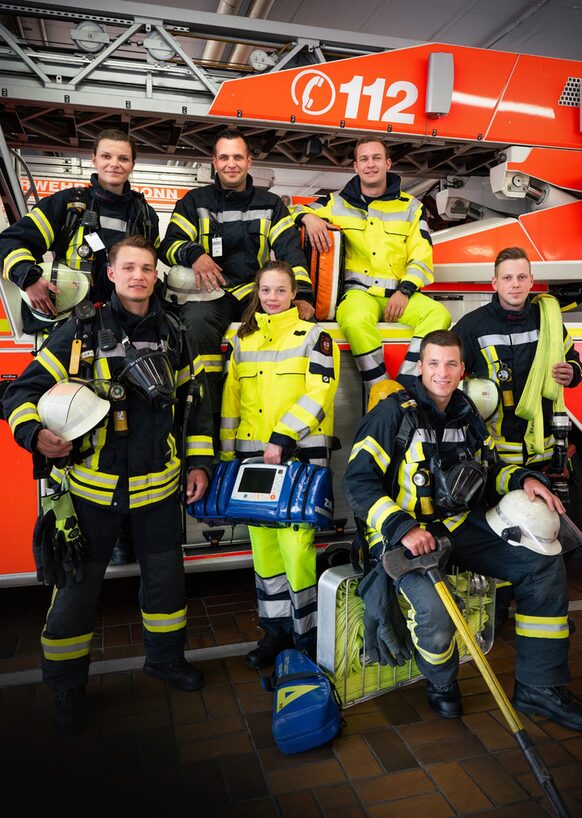 Feuerwehrleute stehen vor einem Einsatzfahrzeug.