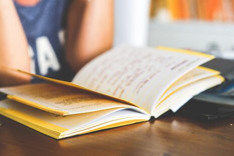 Eine Person liest in einem aufgeschlagenen Buch