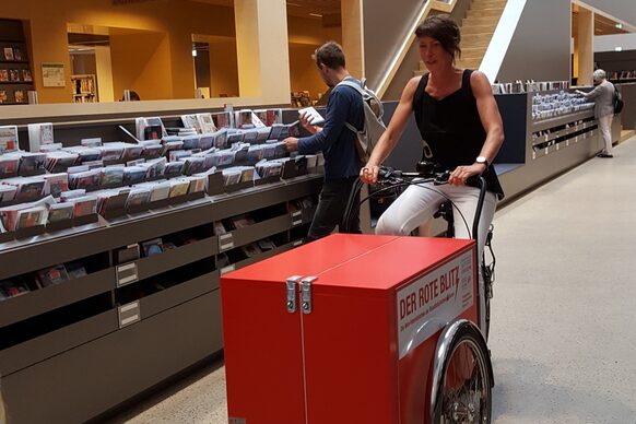 Das rote Lastenfahrrad der Stadtbibliothek im Lichthof des Hauses der Bildung