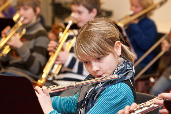 Ein Mädchen spielt Querflöte im Orchester