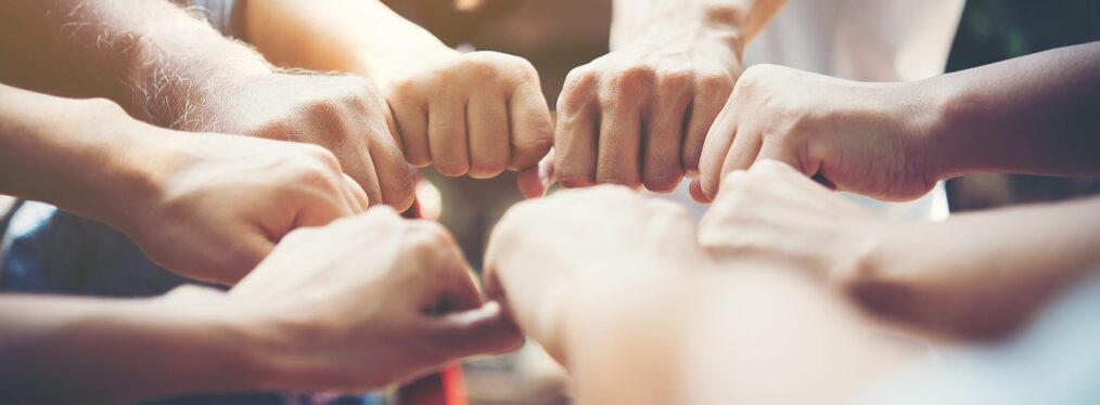 Close up of young people putting their hands together. Team with stack of hands showing unity and teamwork.