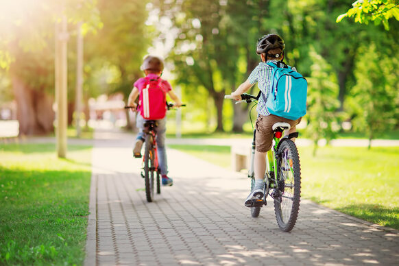 Zwei Kinder fahren Fahrrad.