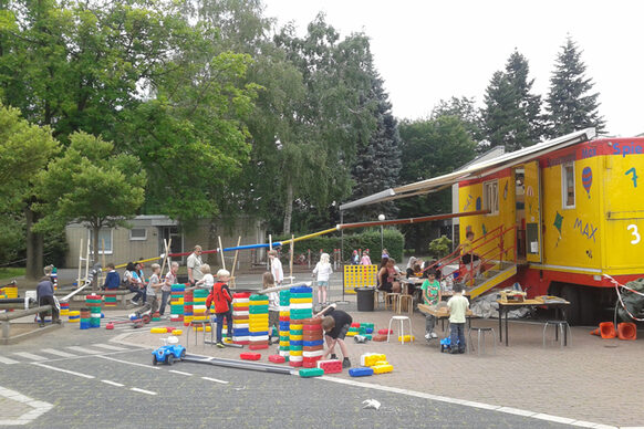 Kinder spielen vor dem Spielmobil Max