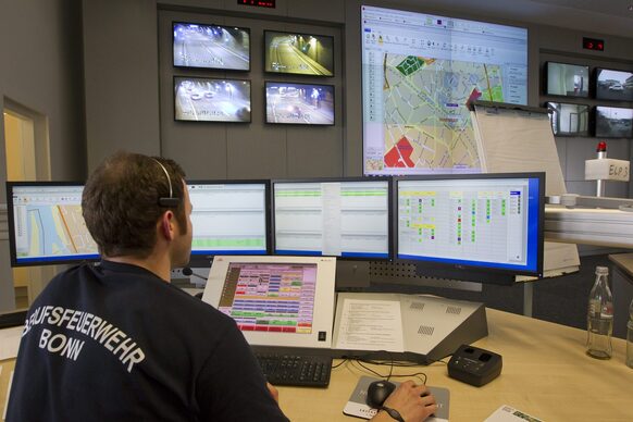 Mitarbeiter vor Monitoren in der Feuerwehrleitstelle