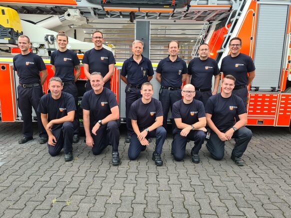 Gruppenfoto von Feuerwehrleuten vor einem Feuerwehrfahrzeug