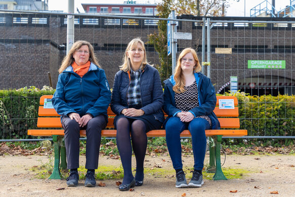 Katja Schülke, Stephanie Clemens-Krämer und Elena Erpenbach auf einer orangen Bank