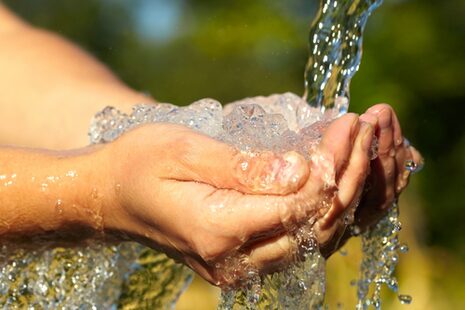 Hände unter einem Wasserstrahl