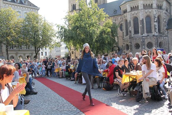 Eine Frau geht auf dem Münsterplatz über einen roten Teppich.