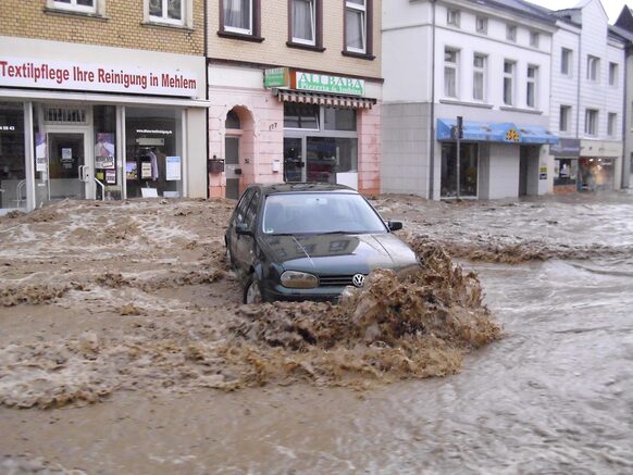 Ein Auto auf einer überfluteten Straße nach einem Starkregen