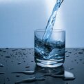 Mineralwasser wird in ein Glas eingegossen